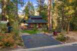 Nestled amidst towering pines, this charming cabin offers a serene retreat with a spacious deck perfect for outdoor dining and relaxation.