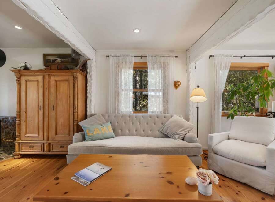 This cozy living room features a tufted sofa and a comfortable armchair, perfect for relaxing.