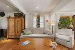 This cozy living room features a tufted sofa and a comfortable armchair, perfect for relaxing.