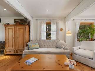 This cozy living room features a tufted sofa and a comfortable armchair, perfect for relaxing.