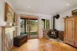 Cozy living room featuring a rustic wood-burning stove set against a stone hearth, perfect for chilly evenings.