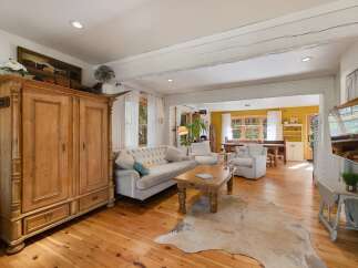 Experience rustic charm in this inviting living space, featuring a large wooden armoire and a plush tufted sofa perfect for relaxation.