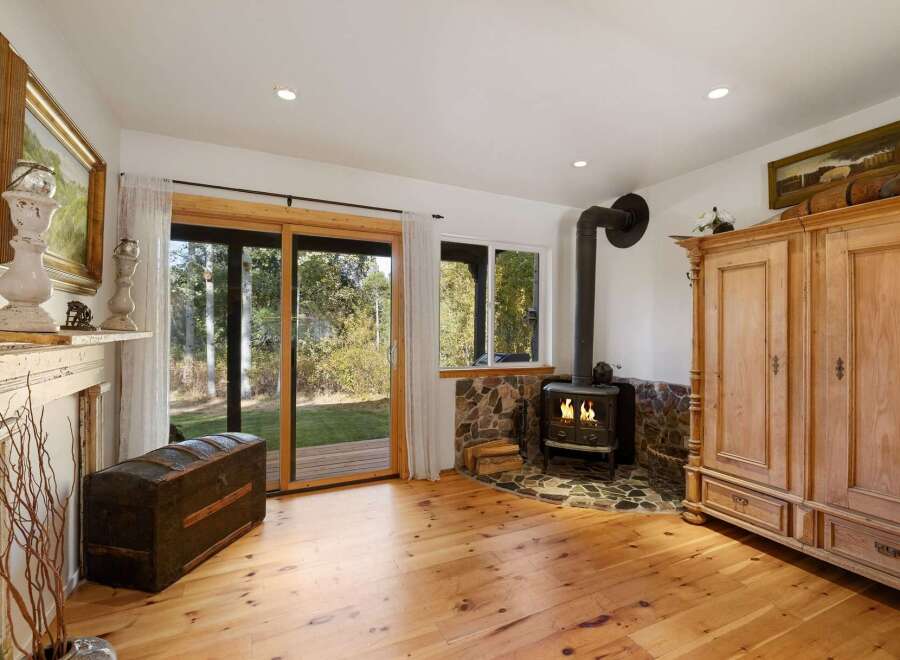 Cozy living room featuring a rustic wood-burning stove set against a stone hearth, perfect for chilly evenings.