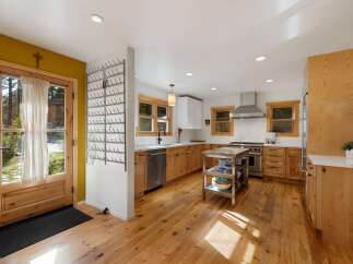 Step into this charming kitchen featuring warm, natural wood cabinetry and a spacious island perfect for meal prep.