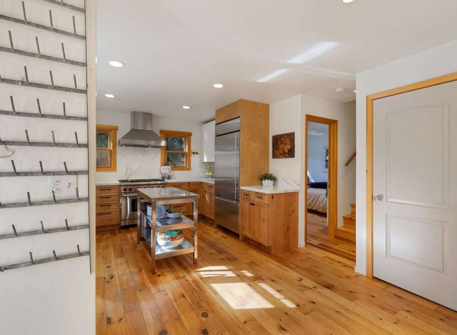 This charming kitchen boasts a professional-grade stainless steel range and hood, complemented by warm wooden cabinetry and sleek marble countertops.