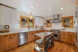 Experience culinary excellence in this stunning kitchen, featuring sleek white cabinetry and warm, natural wood lower cabinets.