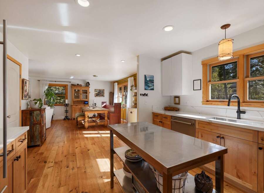 Experience rustic charm in this spacious kitchen and dining area, featuring warm wooden floors and a large island perfect for meal prep.