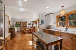 Experience rustic charm in this spacious kitchen and dining area, featuring warm wooden floors and a large island perfect for meal prep.