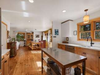 Experience rustic charm in this spacious kitchen and dining area, featuring warm wooden floors and a large island perfect for meal prep.