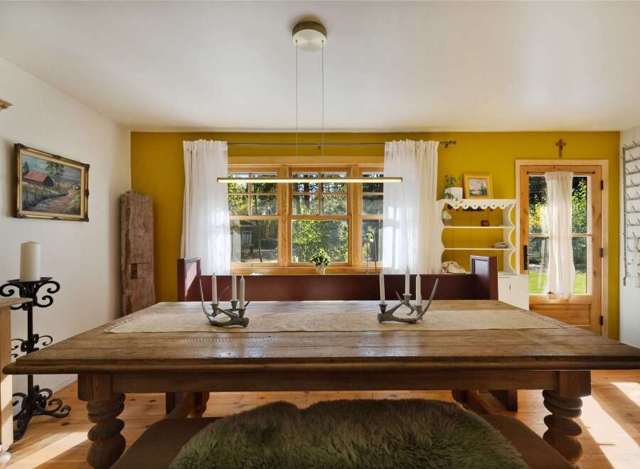 Experience rustic charm in this inviting dining room, featuring a large wooden table perfect for gatherings.