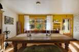 Experience rustic charm in this inviting dining room, featuring a large wooden table perfect for gatherings.