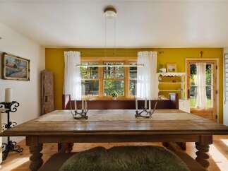 Experience rustic charm in this inviting dining room, featuring a large wooden table perfect for gatherings.