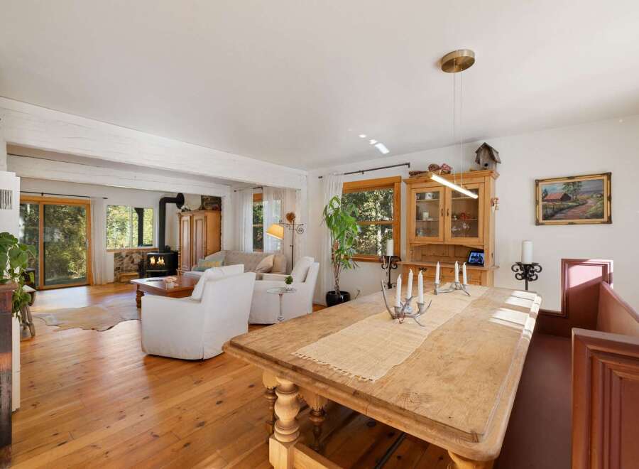 Experience rustic charm in this open-concept living and dining area, featuring a cozy fireplace and abundant natural light.