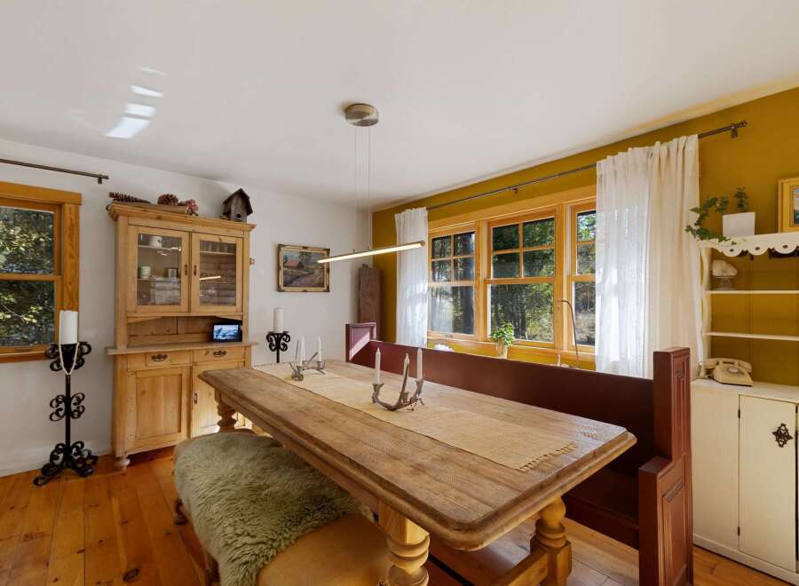 This charming dining room features a rustic wooden table with a textured runner, perfect for intimate gatherings.