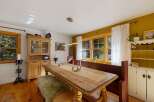 This charming dining room features a rustic wooden table with a textured runner, perfect for intimate gatherings.