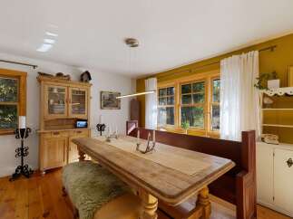 This charming dining room features a rustic wooden table with a textured runner, perfect for intimate gatherings.