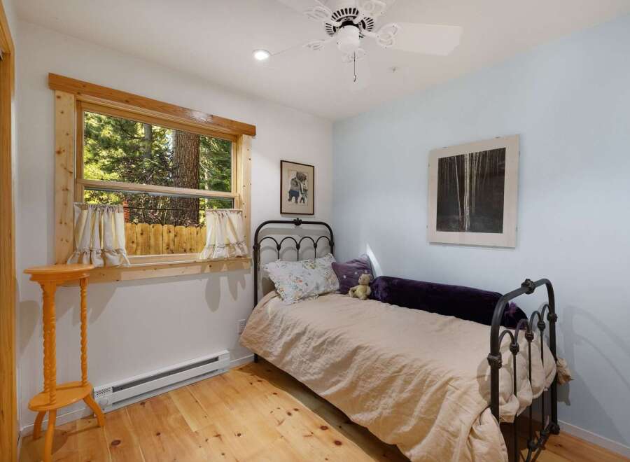 This charming bedroom features a cozy twin bed with a light beige duvet and decorative pillows, perfect for a restful night's sleep.