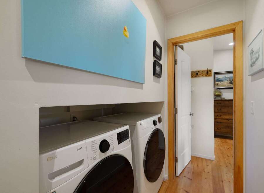 This laundry room features a stacked LG ThinQ washer and dryer set, perfect for efficient cleaning.