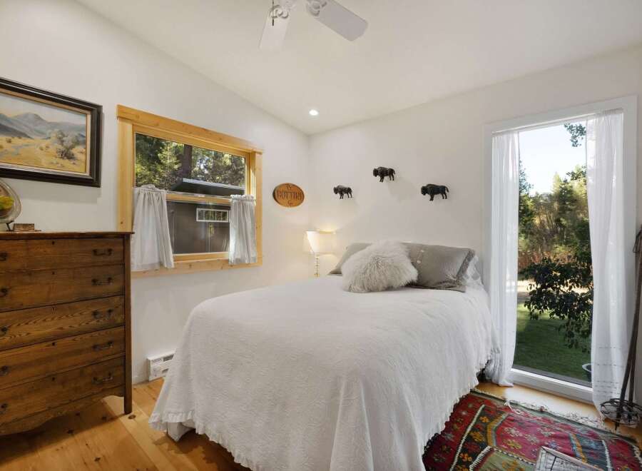 Experience rustic charm in this cozy bedroom, featuring a comfortable bed adorned with plush pillows and a textured quilt.