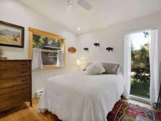 Experience rustic charm in this cozy bedroom, featuring a comfortable bed adorned with plush pillows and a textured quilt.