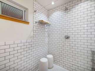 Experience a spa-like retreat in this stunning bathroom featuring a spacious walk-in shower with classic white subway tile and sleek chrome fixtures.