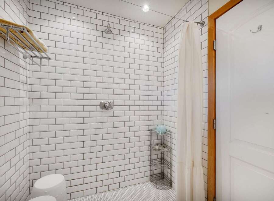 Experience a spa-like retreat in this beautifully tiled shower featuring a rainfall showerhead and a convenient towel rack.