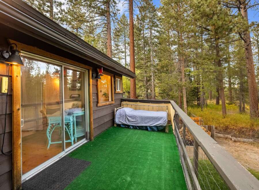 Enjoy the serene mountain setting from this charming cabin's private deck, complete with artificial turf for easy maintenance.