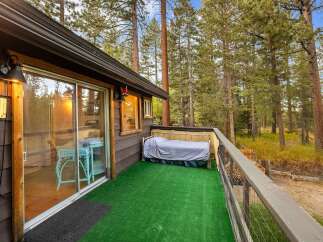 Enjoy the serene mountain setting from this charming cabin's private deck, complete with artificial turf for easy maintenance.