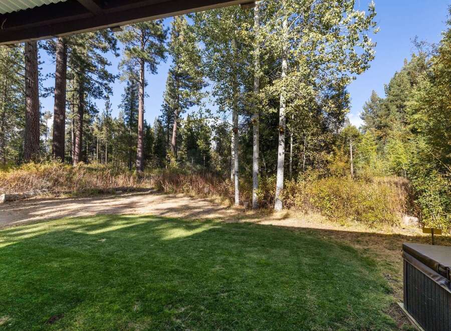Enjoy the serene mountain setting from this property's lush green lawn, perfect for outdoor relaxation.