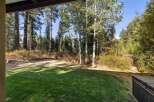 Enjoy the serene mountain setting from this property's lush green lawn, perfect for outdoor relaxation.