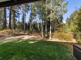Enjoy the serene mountain setting from this property's lush green lawn, perfect for outdoor relaxation.