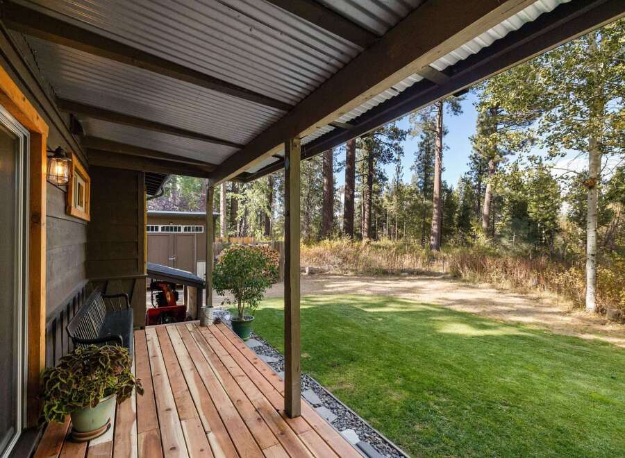 Enjoy the serene outdoors from this charming covered porch, perfect for relaxing with a cup of coffee.