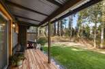 Enjoy the serene outdoors from this charming covered porch, perfect for relaxing with a cup of coffee.