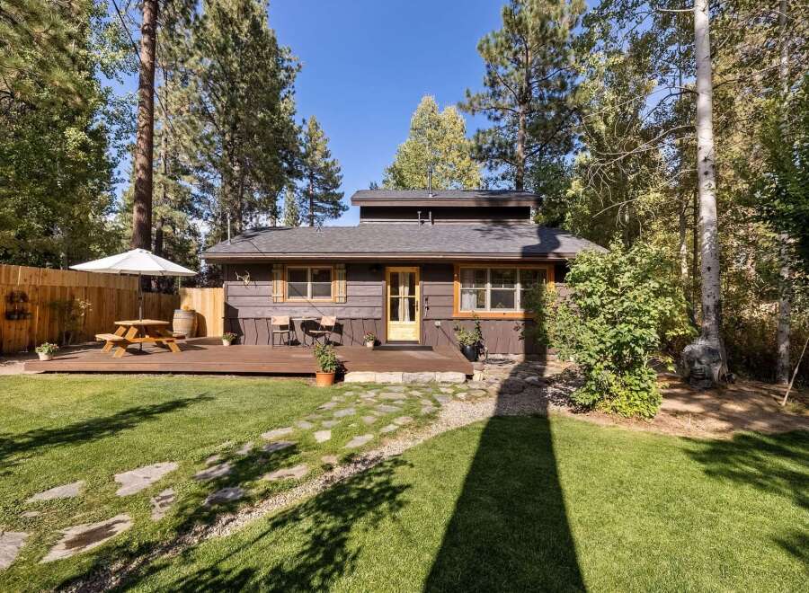 Charming cabin nestled among mature trees, offering a serene retreat.