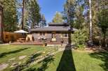Charming cabin nestled among mature trees, offering a serene retreat.