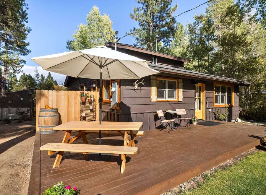 Enjoy outdoor living on this charming property featuring a spacious wooden deck perfect for entertaining.