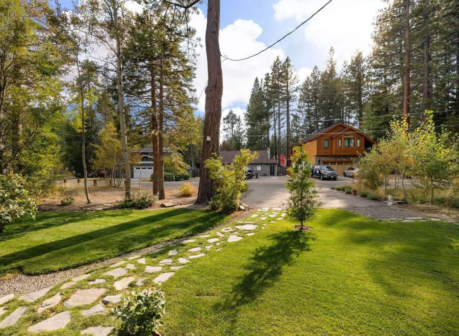 Discover this charming property featuring a beautifully maintained lawn and a picturesque stone pathway leading to the entrance.