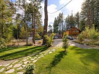 Discover this charming property featuring a beautifully maintained lawn and a picturesque stone pathway leading to the entrance.
