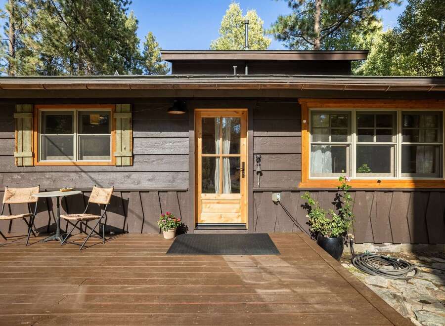 Charming cabin exterior featuring a warm wooden deck, perfect for enjoying the surrounding nature.