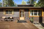 Charming cabin exterior featuring a warm wooden deck, perfect for enjoying the surrounding nature.