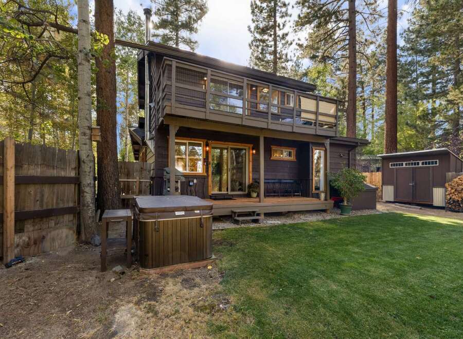 Escape to this charming cabin nestled among tall pine trees, offering a private backyard oasis.