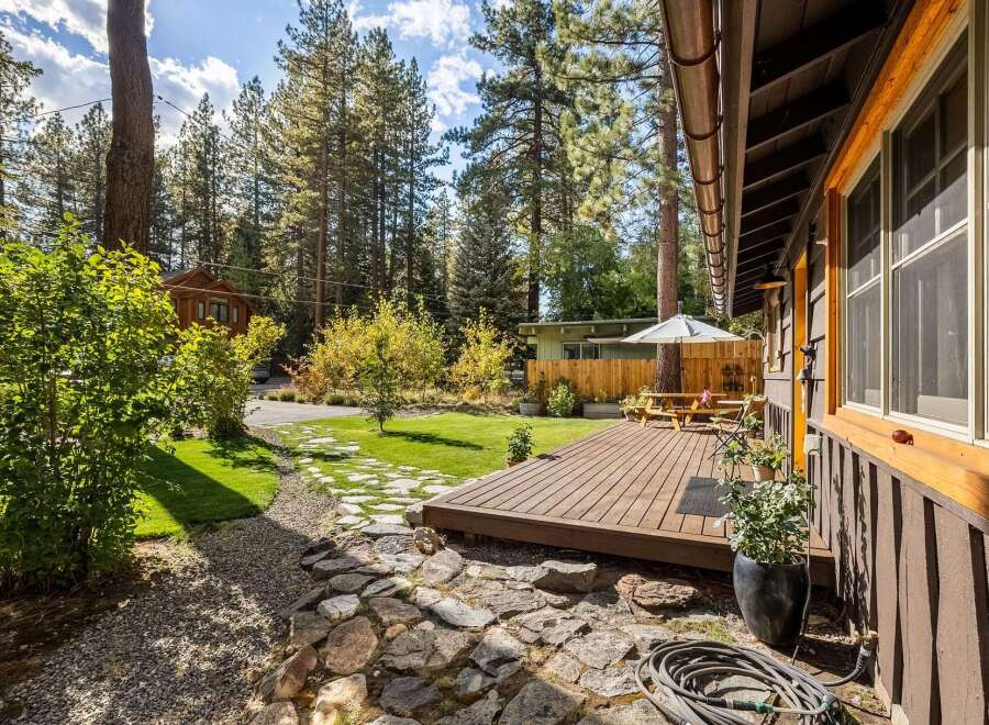 Enjoy outdoor living in this charming home featuring a spacious wooden deck perfect for entertaining.