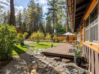 Enjoy outdoor living in this charming home featuring a spacious wooden deck perfect for entertaining.