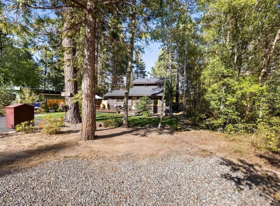Nestled among mature trees, this charming home offers a serene retreat with a spacious deck perfect for outdoor entertaining.