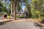 Nestled among mature trees, this charming home offers a serene retreat with a spacious deck perfect for outdoor entertaining.