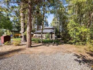 Nestled among mature trees, this charming home offers a serene retreat with a spacious deck perfect for outdoor entertaining.