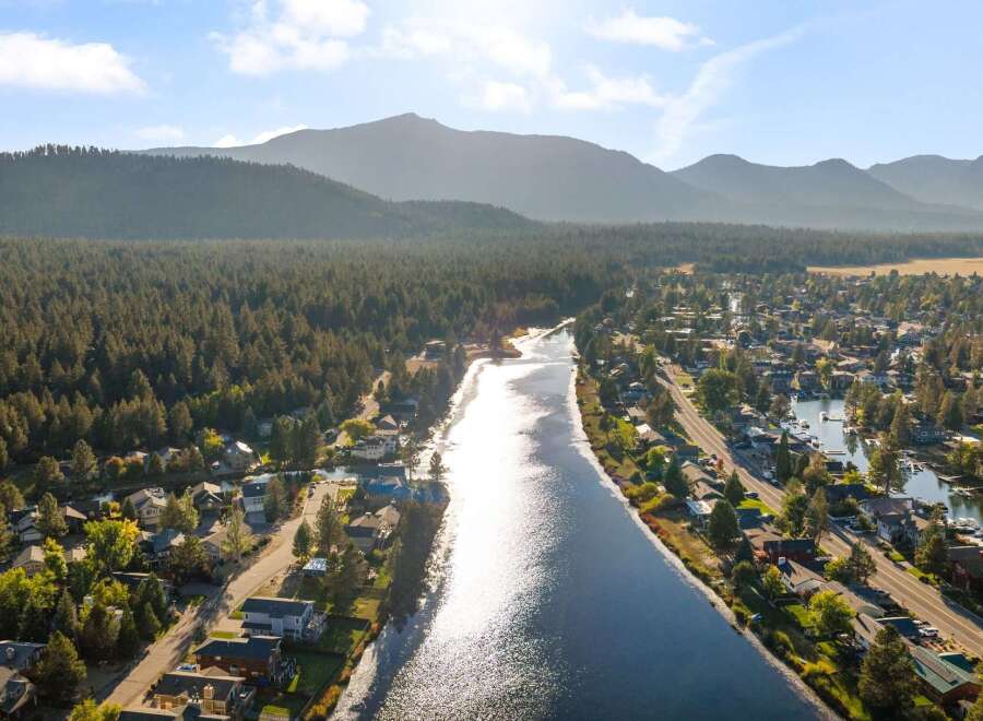 Experience waterfront living at its finest in this stunning aerial view of a picturesque community nestled along a serene river.