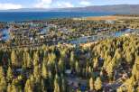 Experience the ultimate lakeside living in this stunning aerial view of a waterfront community nestled amongst lush pine trees.