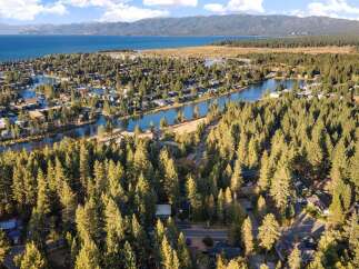 Experience the ultimate lakeside lifestyle with this stunning aerial view of a waterfront community nestled among tall pine trees.