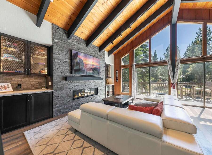 Experience luxury mountain living in this stunning great room, featuring a modern gas fireplace set against a dramatic stacked stone accent wall.